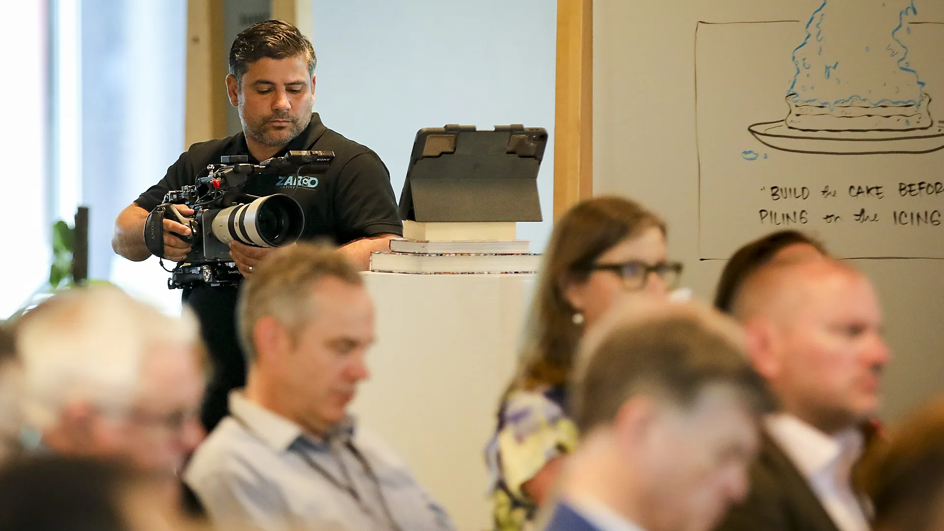 Oscar Vieira filming an audience at a corporate event in Sydney