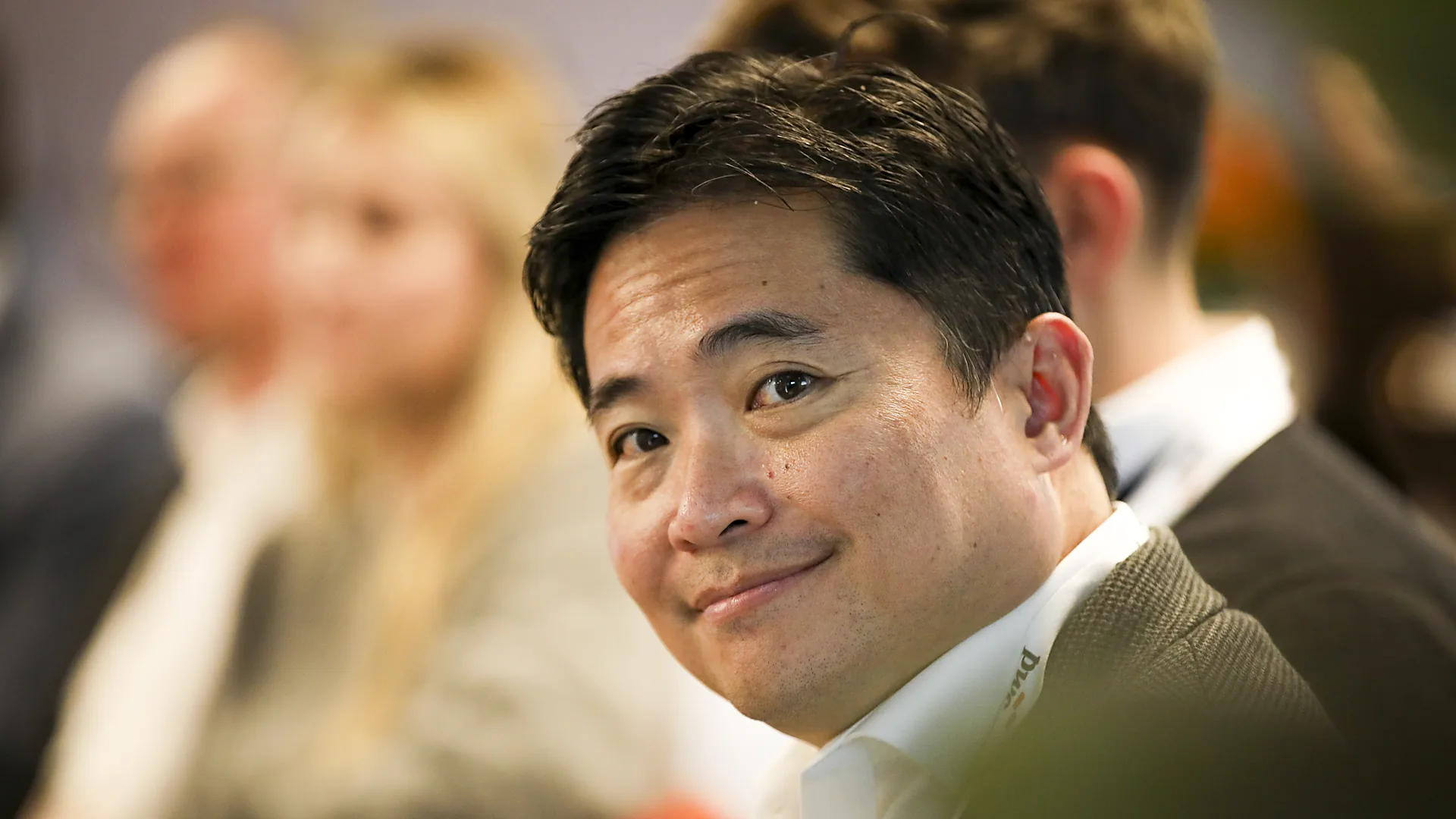 A smiling guest in the audience at a corporate event in Sydney, filmed by Zarco Creative