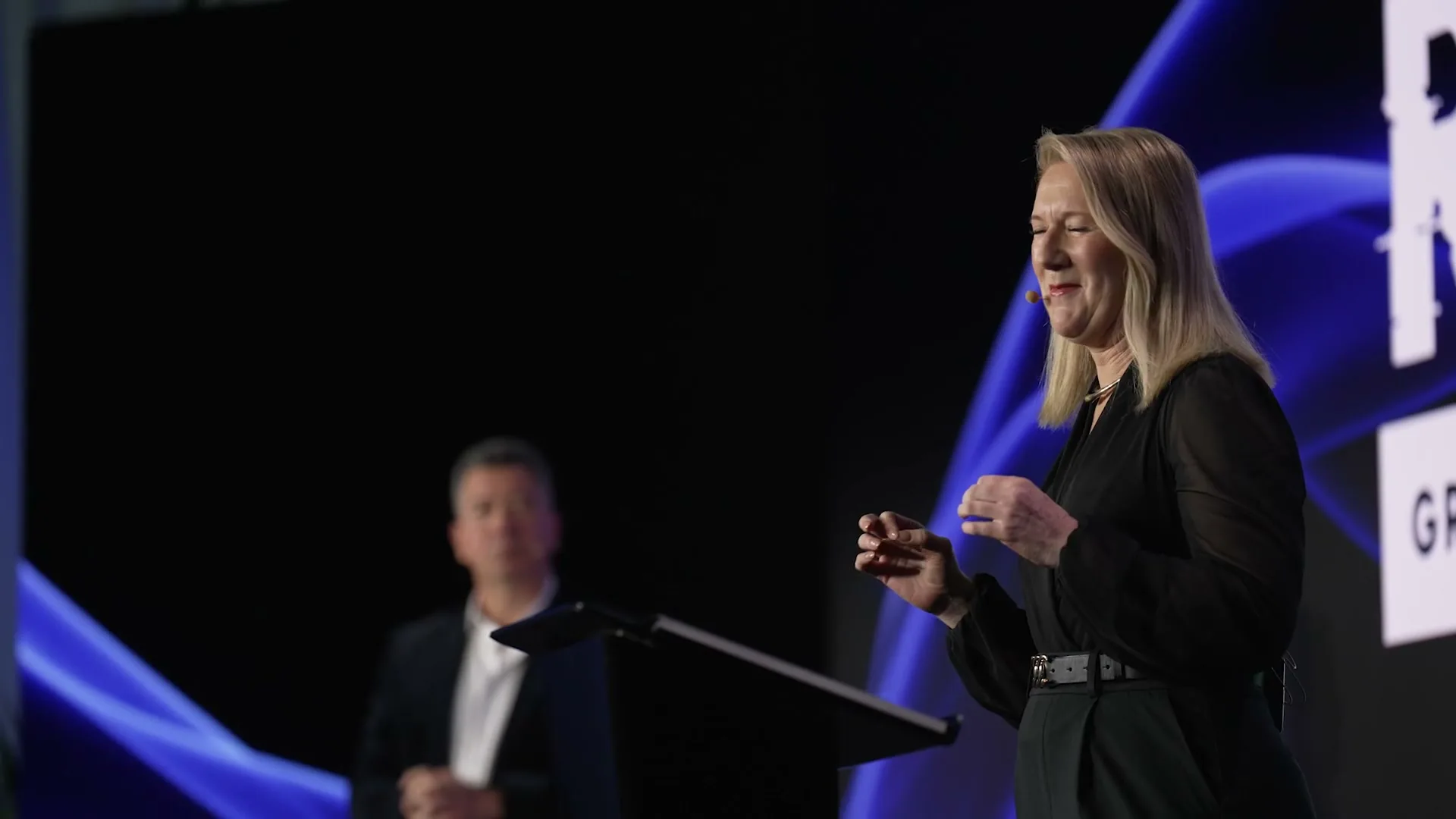 A presenter smiling on stage at RESET 2026 in Sydney, filmed by Zarco Creative