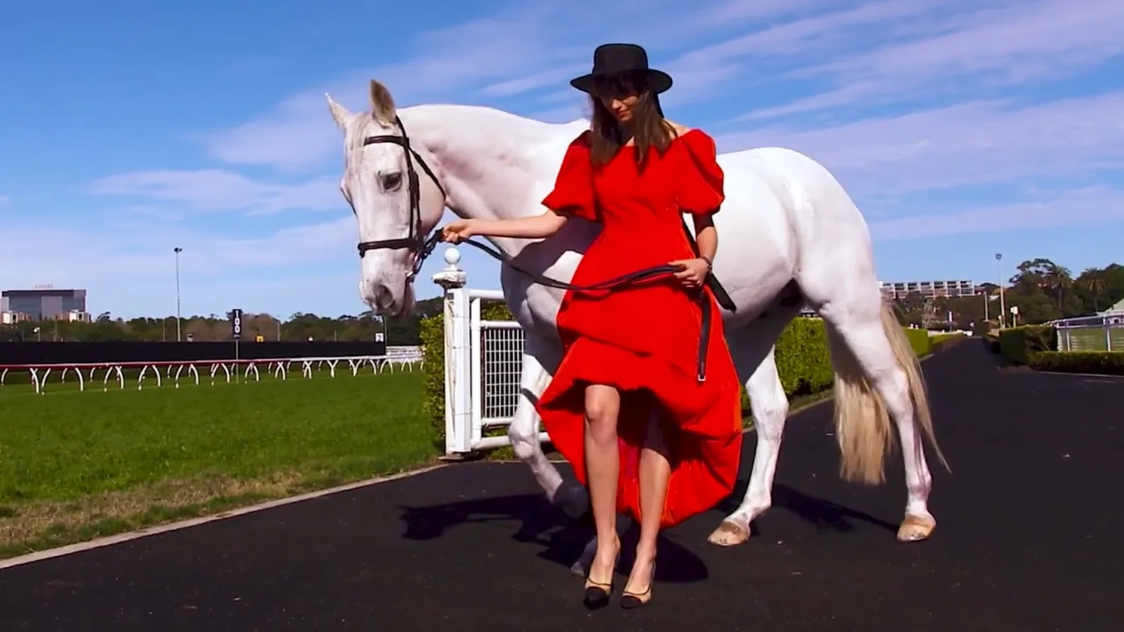 Model in a red gown with a white horse at Royal Randwick, filmed by Zarco Creative