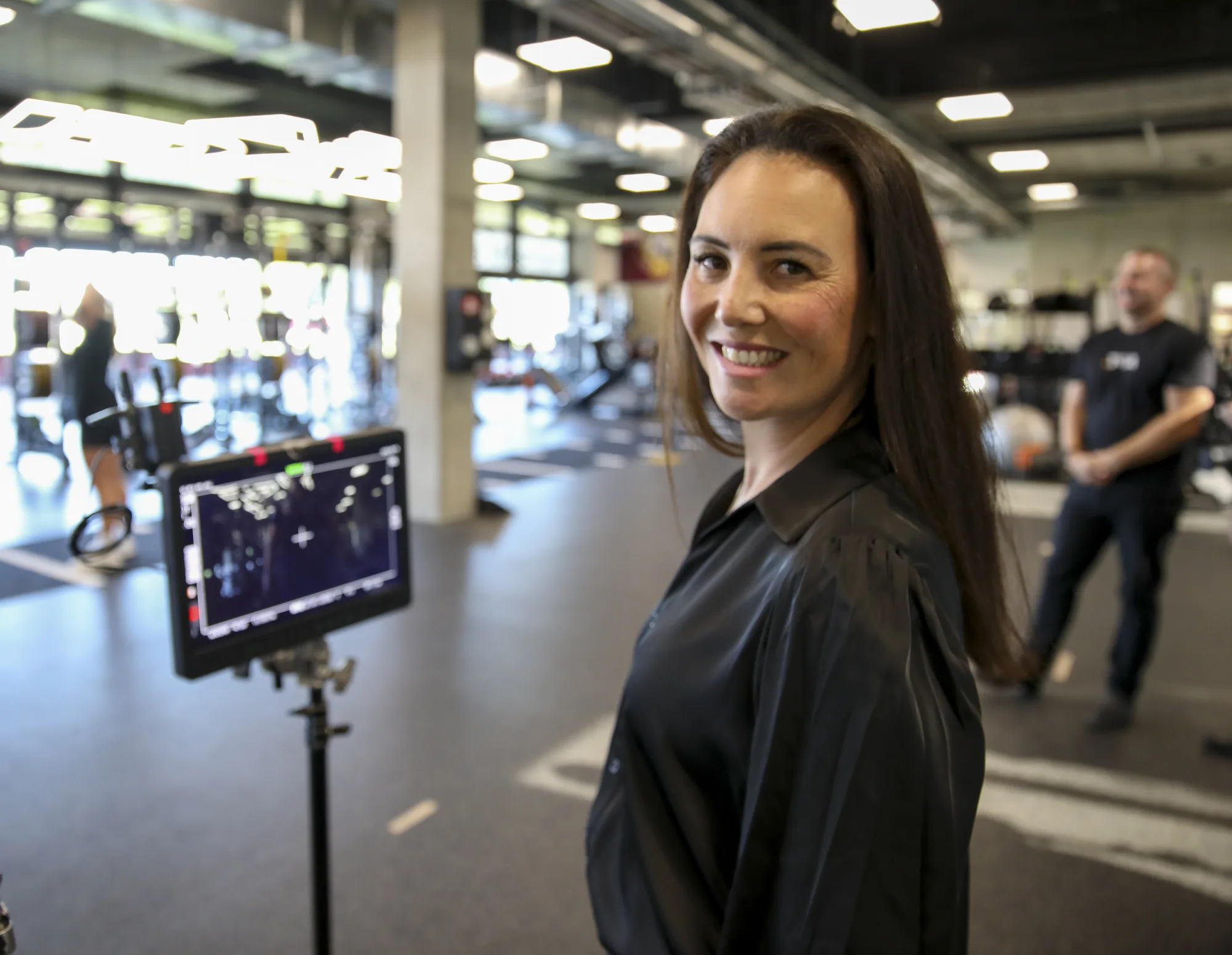 Jess Vieira from Zarco Creative smiling beside a camera monitor on a corporate shoot in Sydney