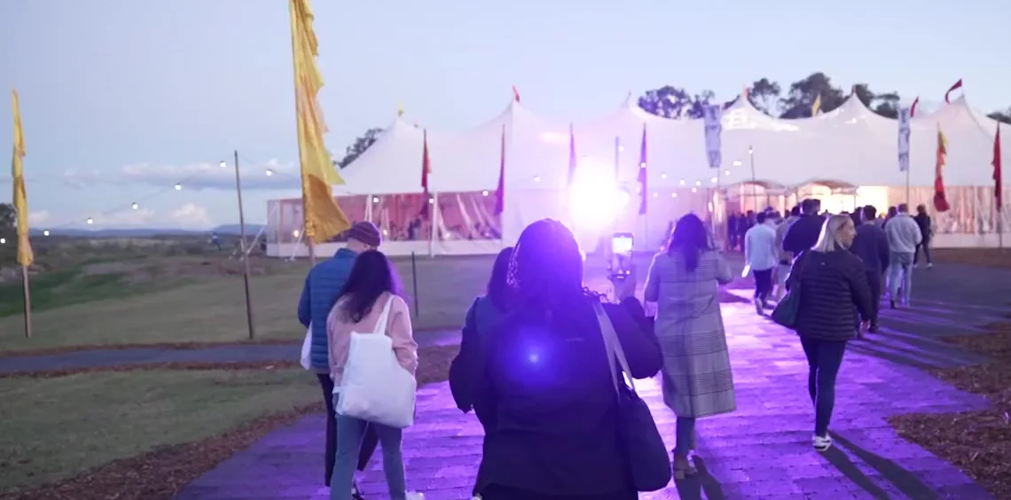 Participants walking a lit pathway towards the main marquee at The Outside, PwC Australia's signature experience in the Hunter Valley