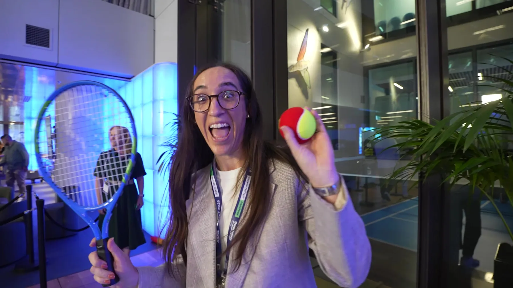 A delegate laughing with a tennis racquet at the Tennis Australia activation at RESET 2026, filmed by Zarco Creative