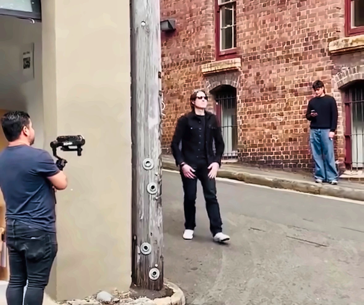 Behind the scenes on Who Is Eric J: our camera operator on a gimbal, filming Eric J in a laneway