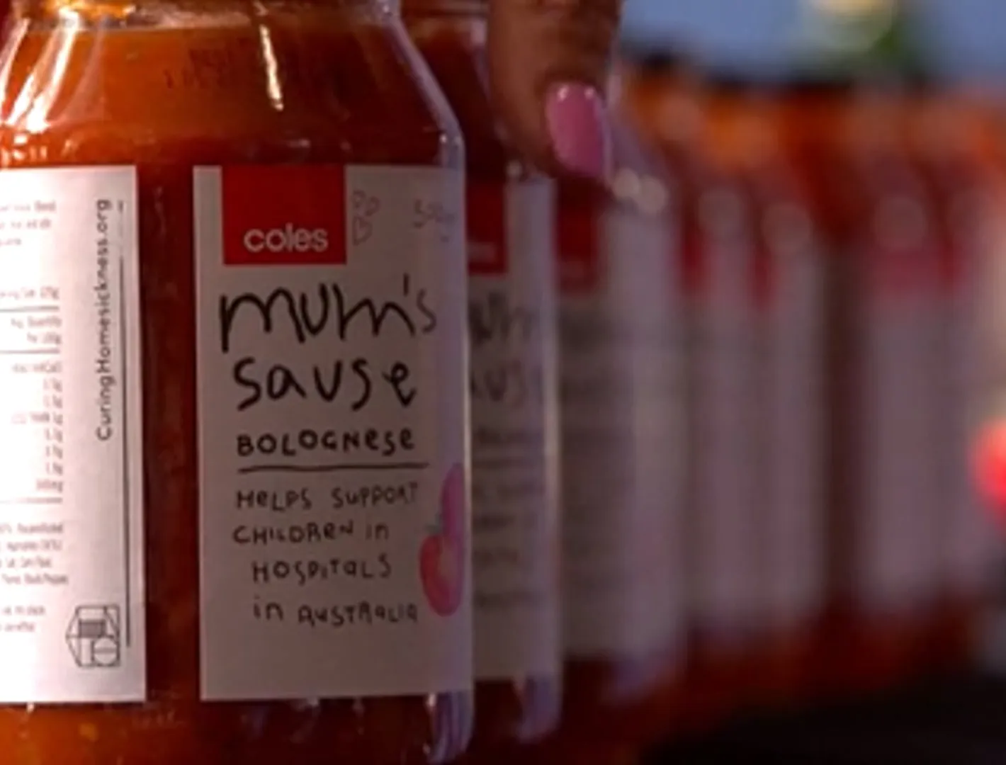Coles team in chef hats with the Mum's Sauce jar at a children's hospital cook-along, filmed by Zarco Creative