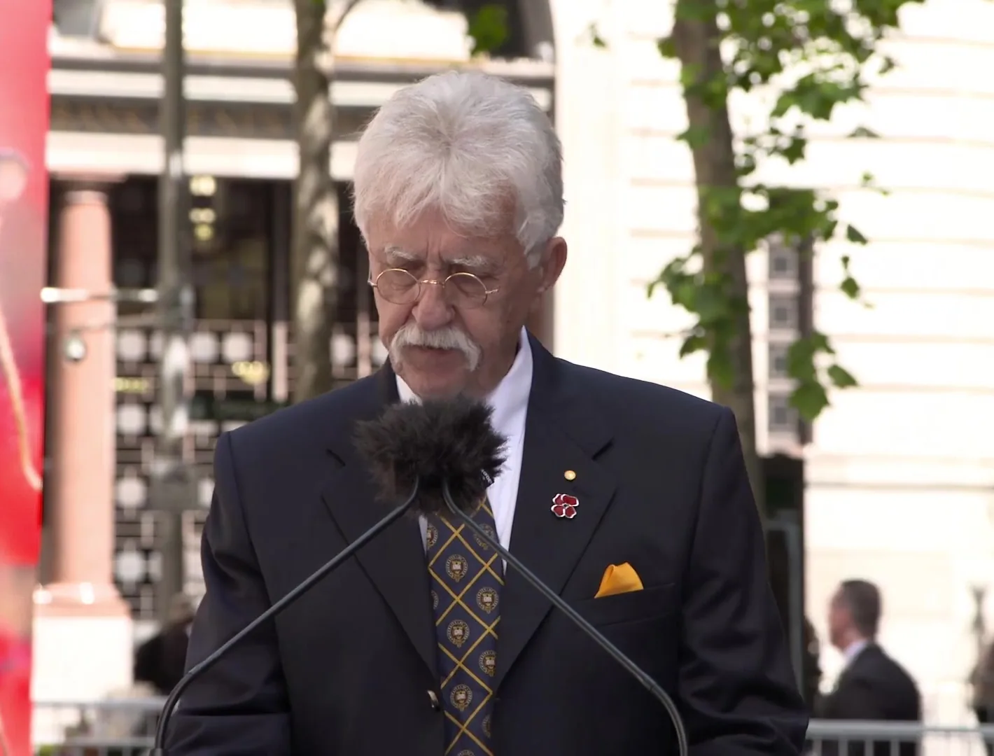 Speaker at the lectern during the NSW Government Remembrance Day service, streamed by Zarco Creative
