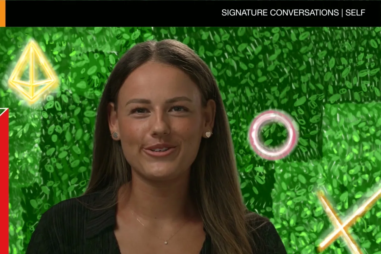 A smiling PwC Academy participant on camera against the hedge wall at The Outside, filmed by Zarco Creative